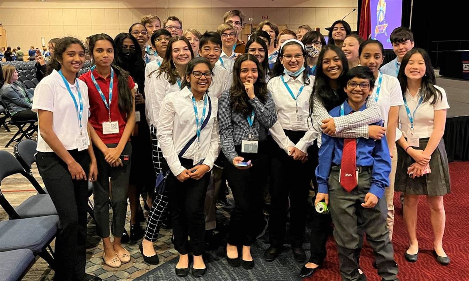 A group of students smiles while at a State conference